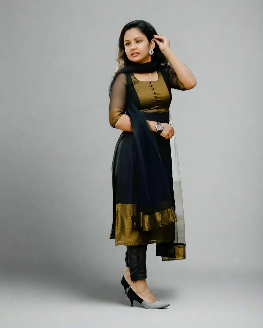 Woman wearing a black and gold traditional outfit with a white background